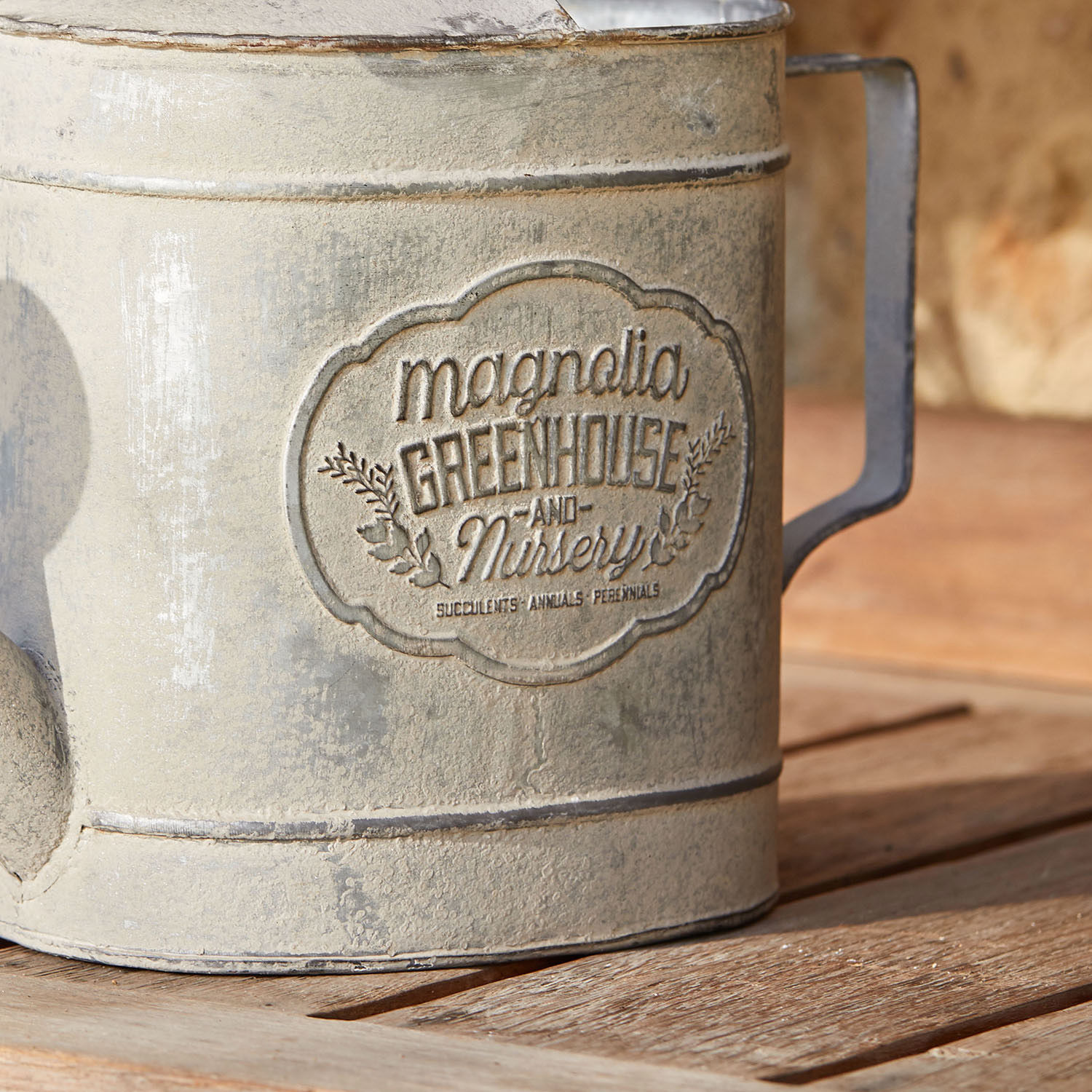 Vintage graue Metall-Gießkanne auf Holztisch für Gartenarbeit