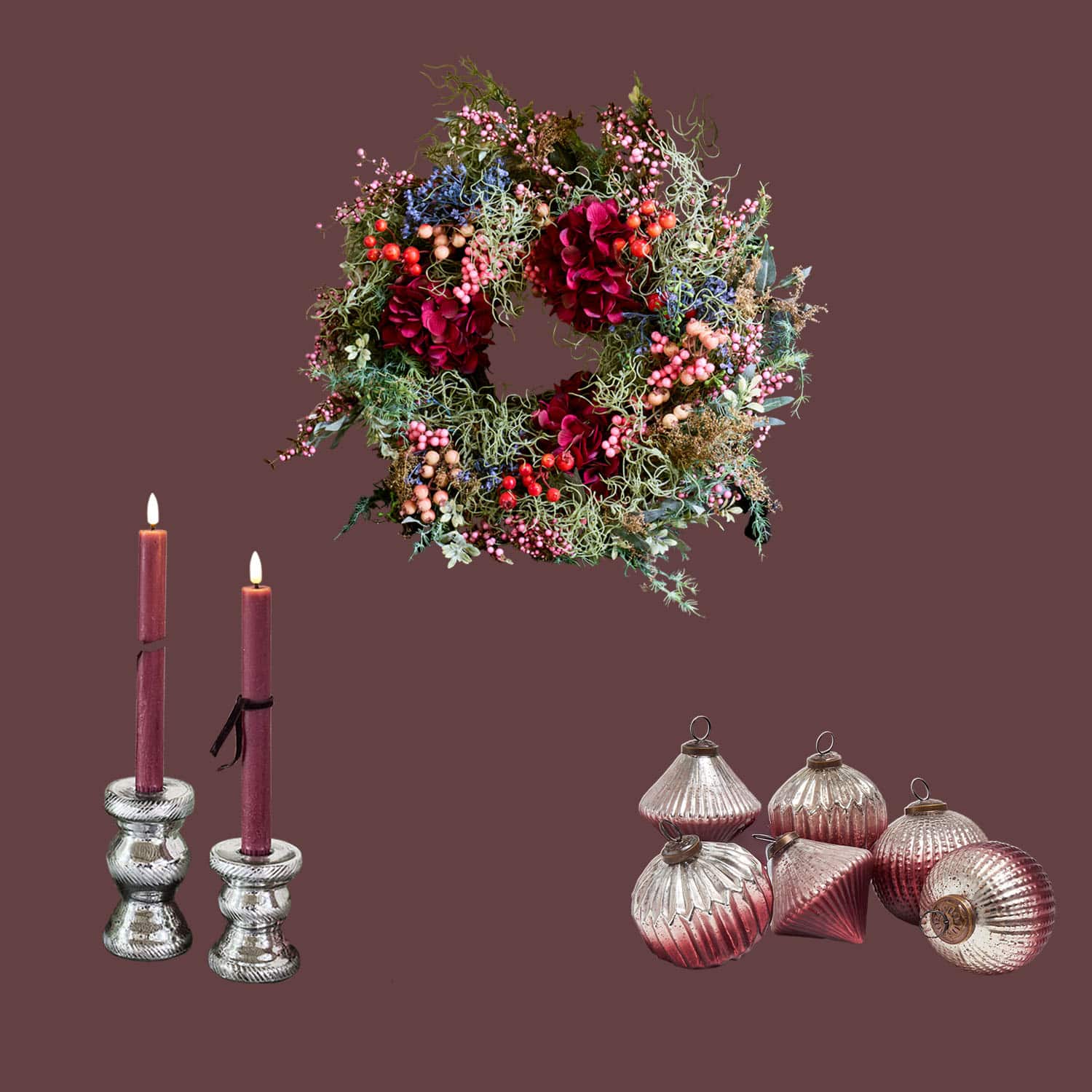 Dekorativer Kranz mit roten Blumen und Beeren, bordeauxfarbene Kerzen in silbernen Kerzenhaltern, Weihnachtsdekoration