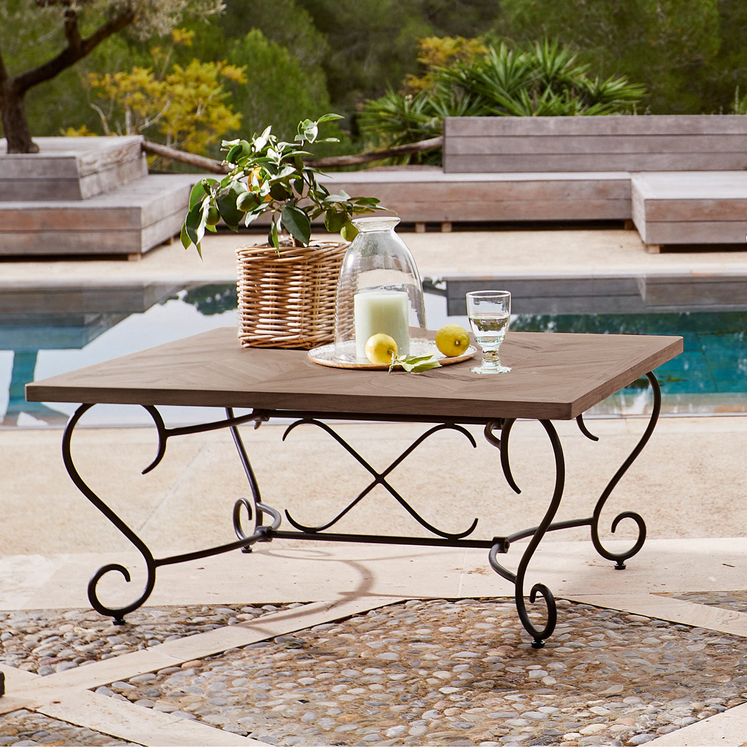 Quadratischer Tisch mit Holzplatte und Metallbeinen auf Terrasse am Pool