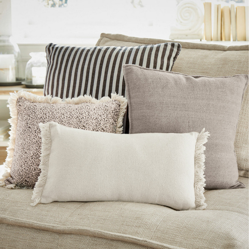 Set aus dekorativen Kissen in Beige- und Brauntönen auf beigem Sofa, weiche Materialien, Wohnzimmerdeko