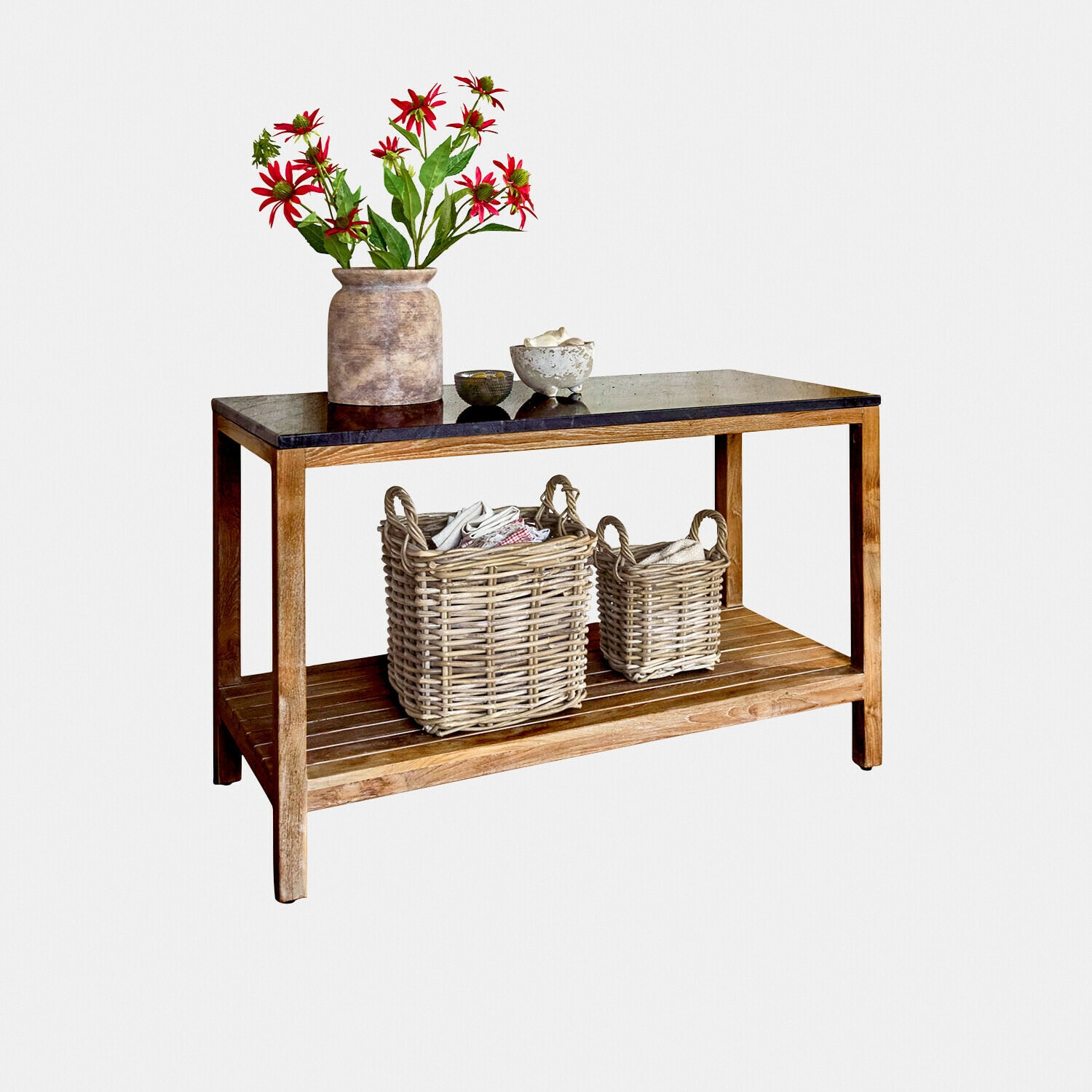 Holztisch mit schwarzer Tischplatte, zwei Korbaufbewahrungen und Vase mit roten Blumen als Dekoration