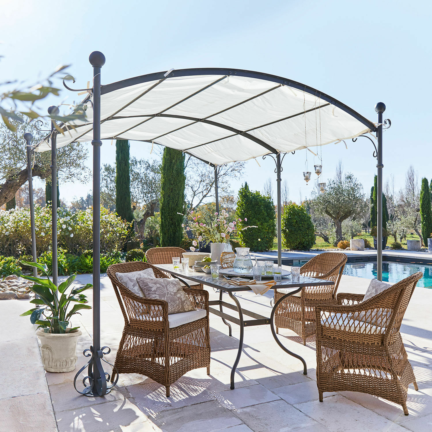 Gartenmöbel-Set aus Rattan mit Kissen unter weißem Metallpavillon am Pool