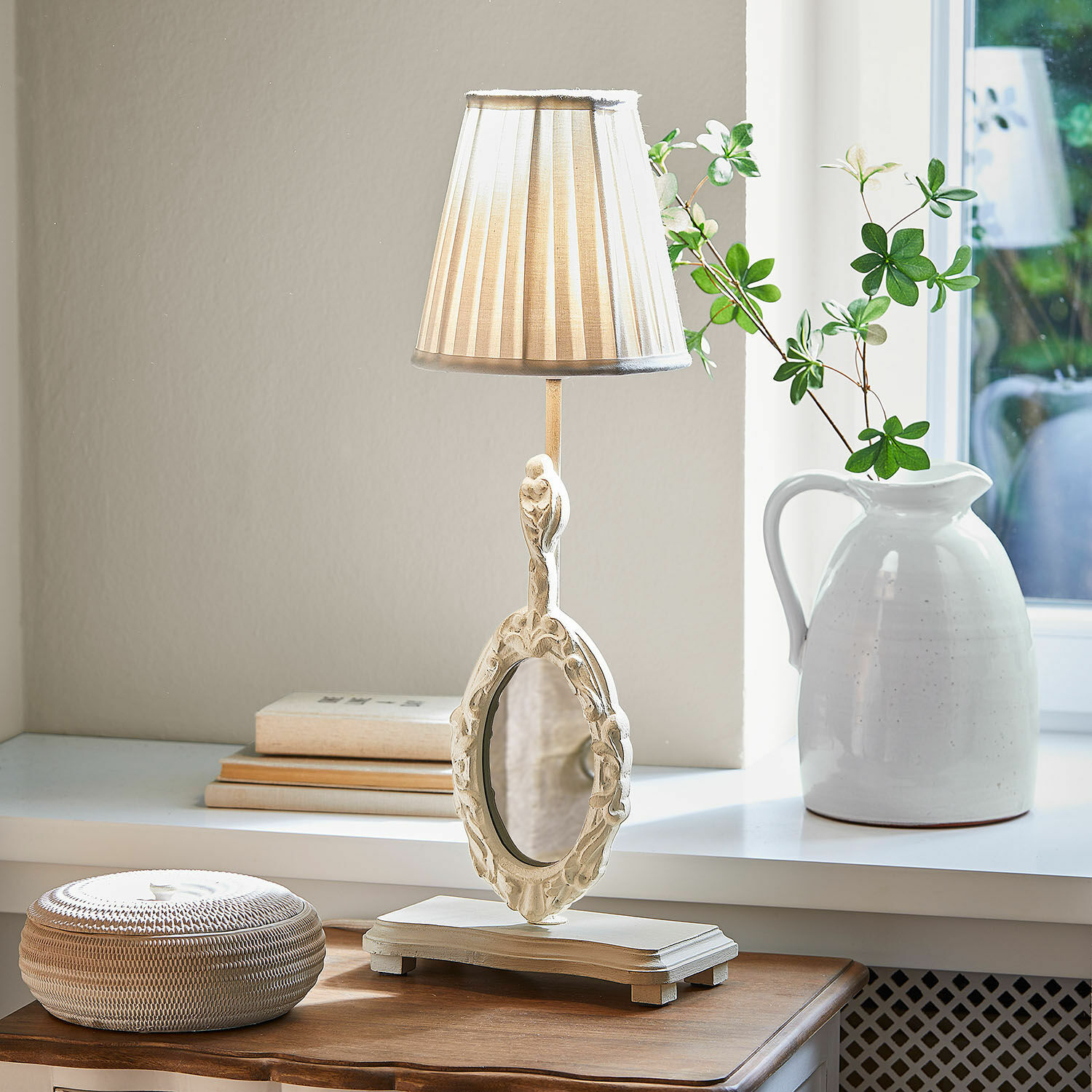 Tischlampe mit Spiegel Brannach Tischlampe aus weißem Holz mit verziertem Spiegel und beigem Schirm auf Holzuntergrund