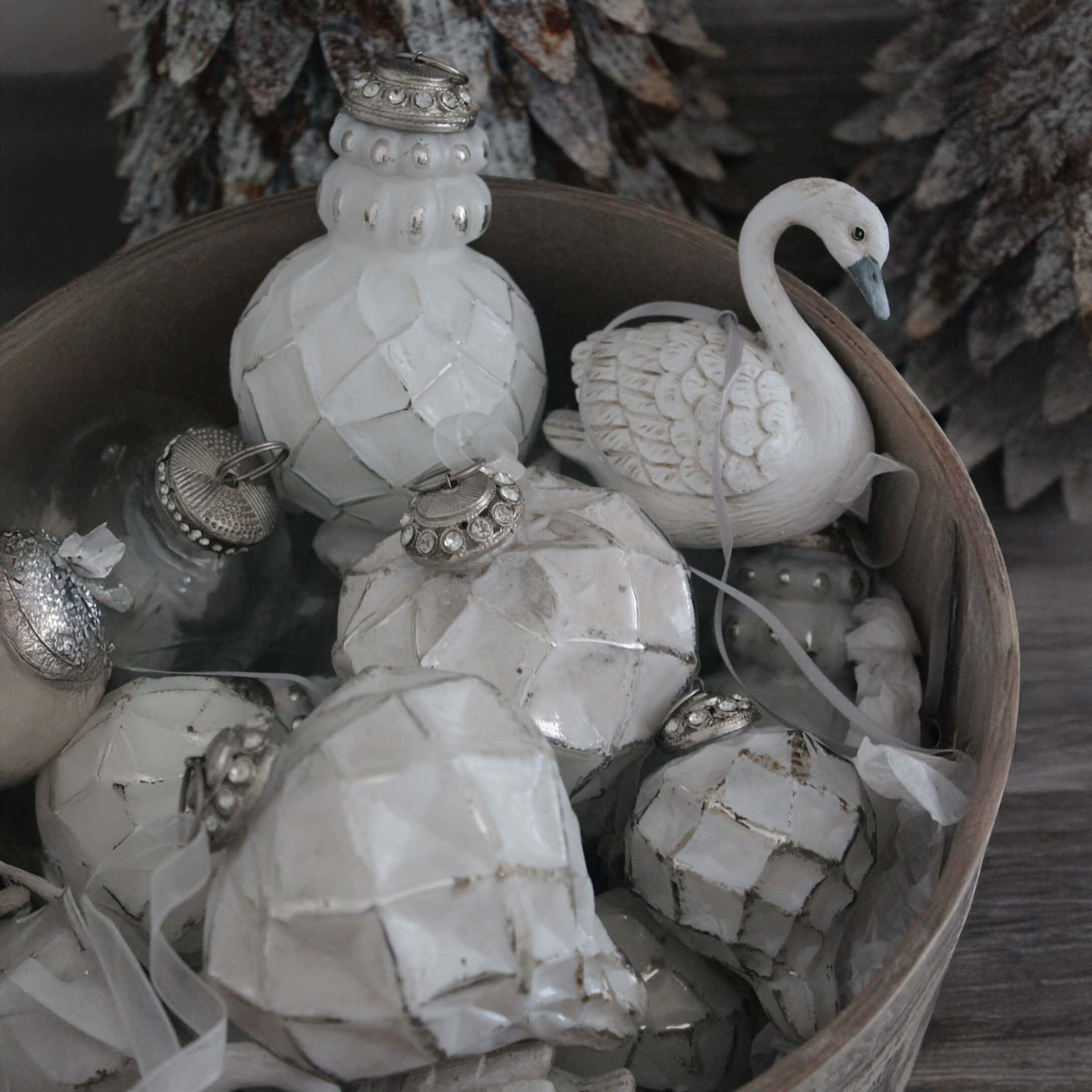 Weiße Weihnachtsdekorationen aus Keramik und Glas in einer Holzkiste, winterliche Ornamente