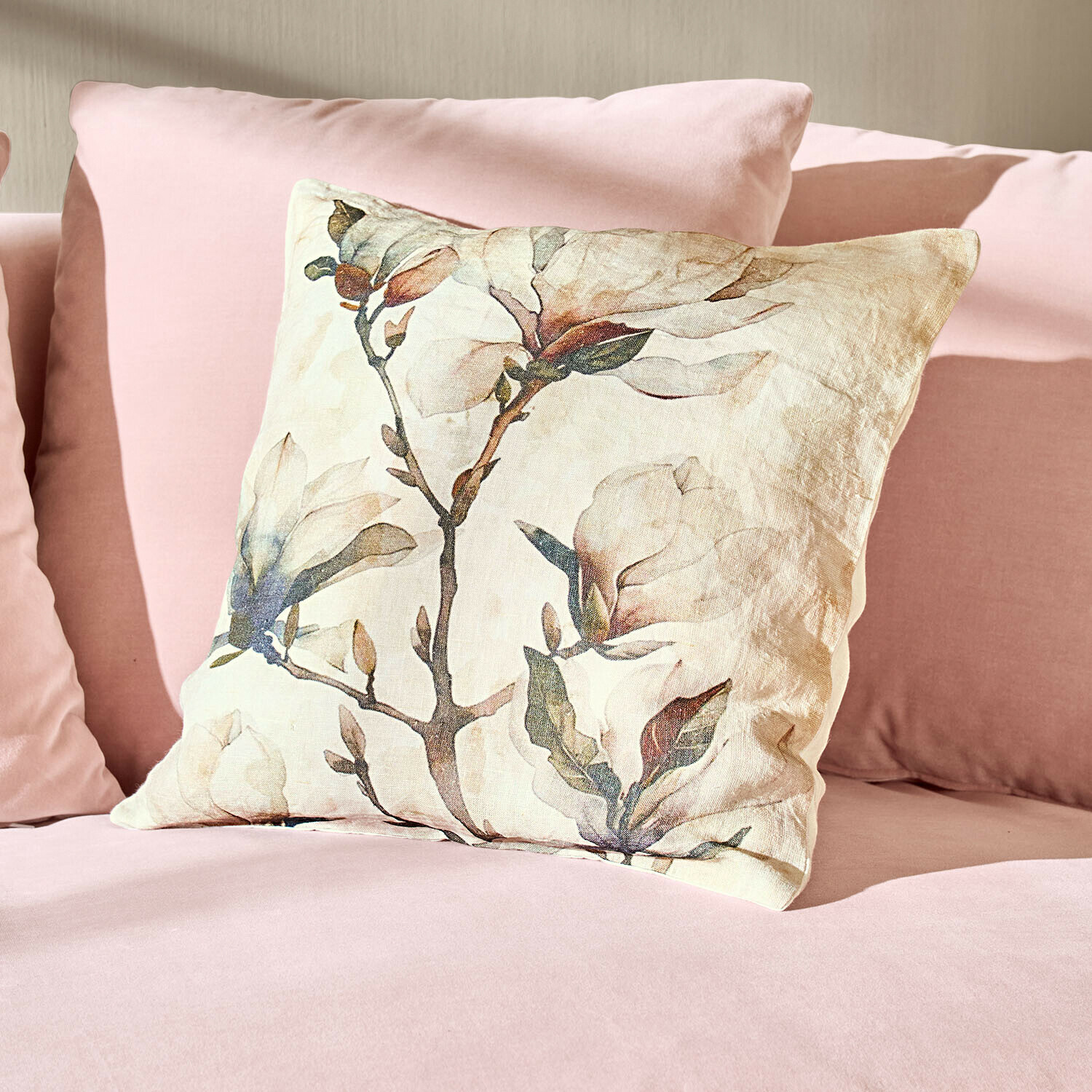 Leinenkissen mit floralem Design auf rosa Couch, weiche und stilvolle Einrichtungsidee