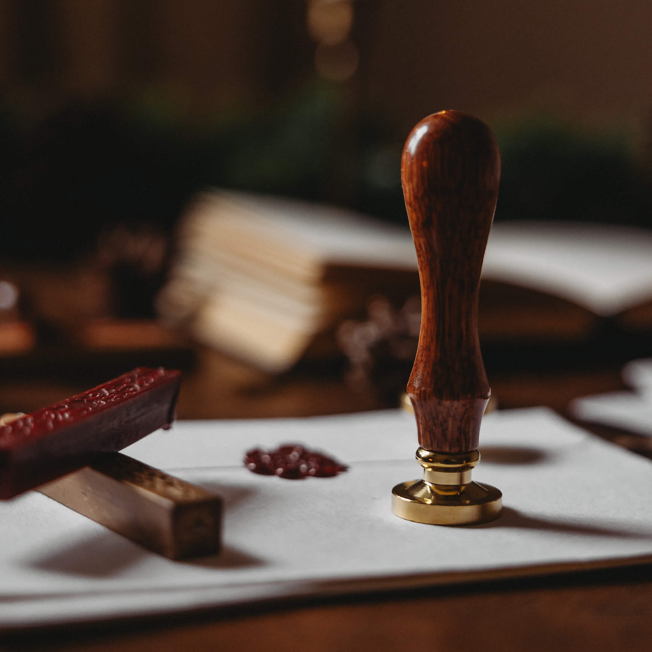 Briefsiegel mit Holzgriff und Messingbasis auf weißem Umschlag mit rotem Wachs