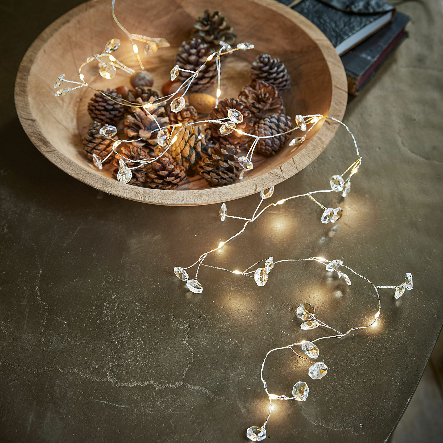 Lichterkette Laurits Holzschale mit Zapfen und zartem Lichterkette mit Kristallanhängern auf Tisch