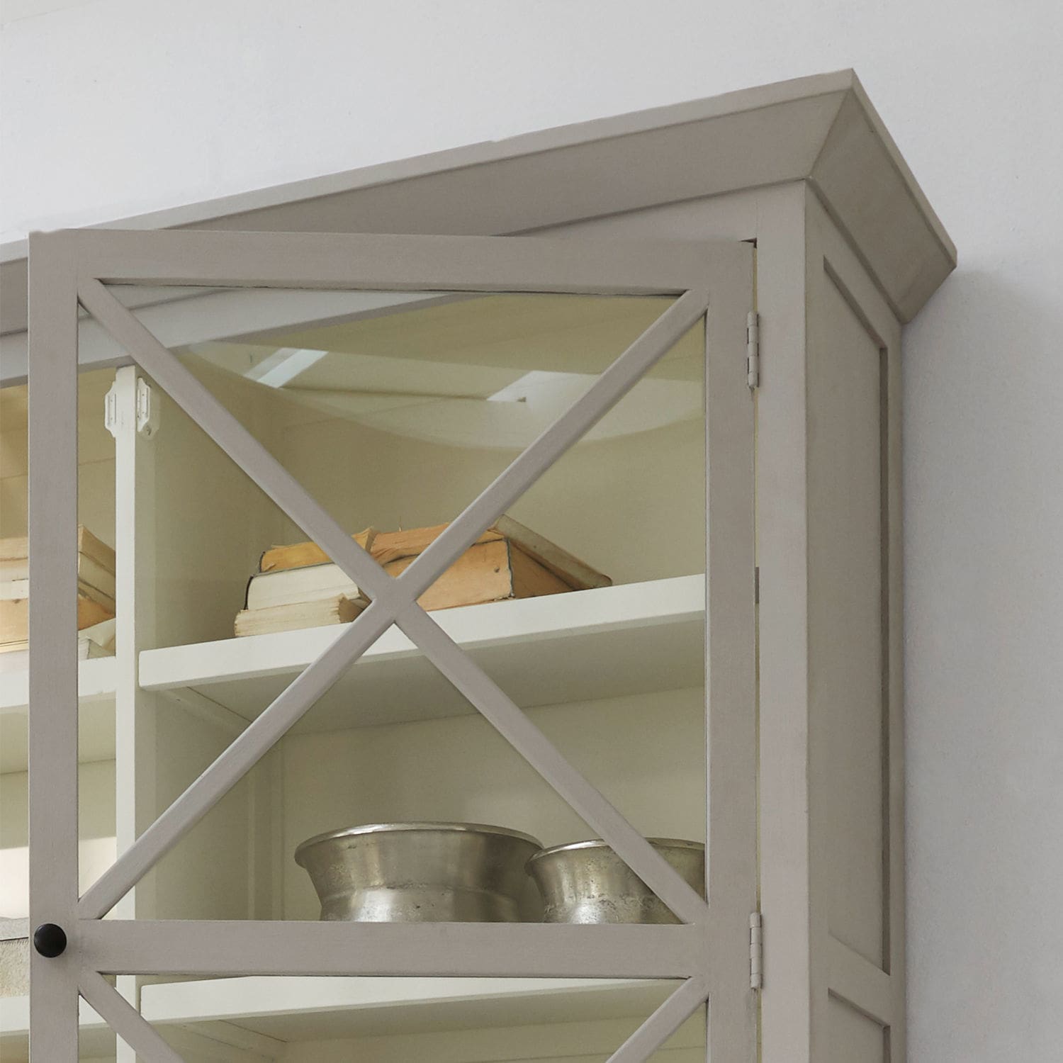 Grauer Holzvitrinenschrank mit Glastür und Metallschalen auf dem Regal, elegantes Wohnzimmermöbel