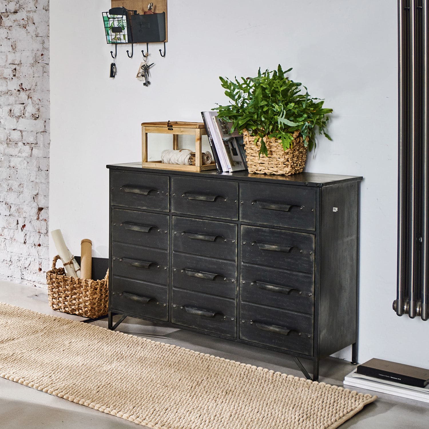 Kommode Mandres Schwarze Metallkommode im Industriestil mit Schubladen, dekoriert mit Pflanze und Büchern