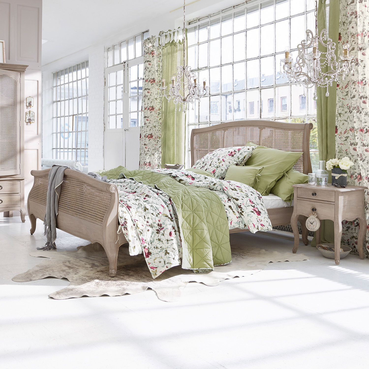 Bett Truso Schlafzimmer mit Holzbett und grün-blumiger Bettwäsche in hellem, natürlichem Stil