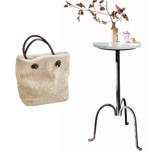 Beige Tasche aus weichem Material mit dunklen Griffen neben einem Tisch mit Marmorplatte und Metallgestell