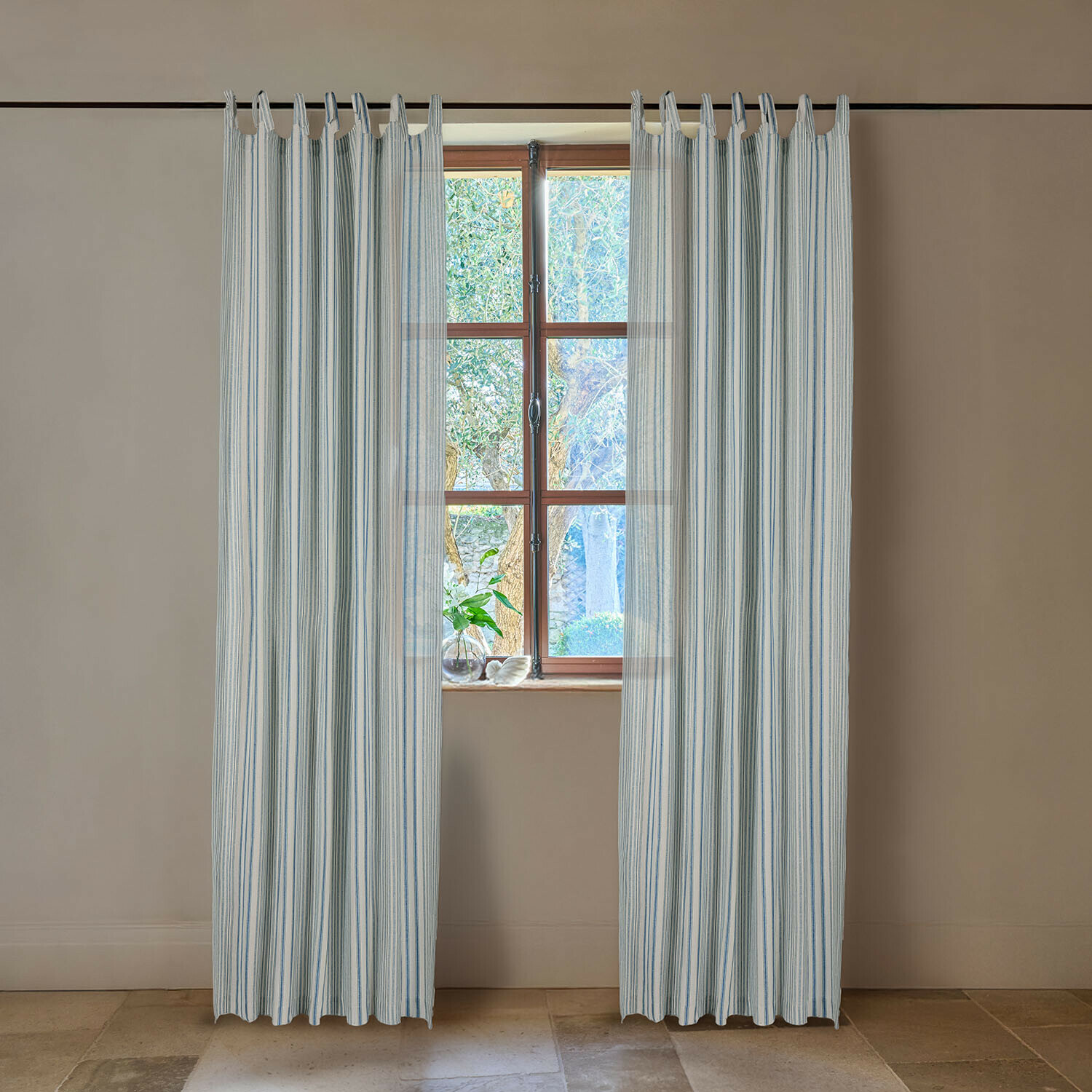 Weiße Vorhänge mit blauen Streifen aus leichtem Stoff, Fensterdekoration in hellem Raum