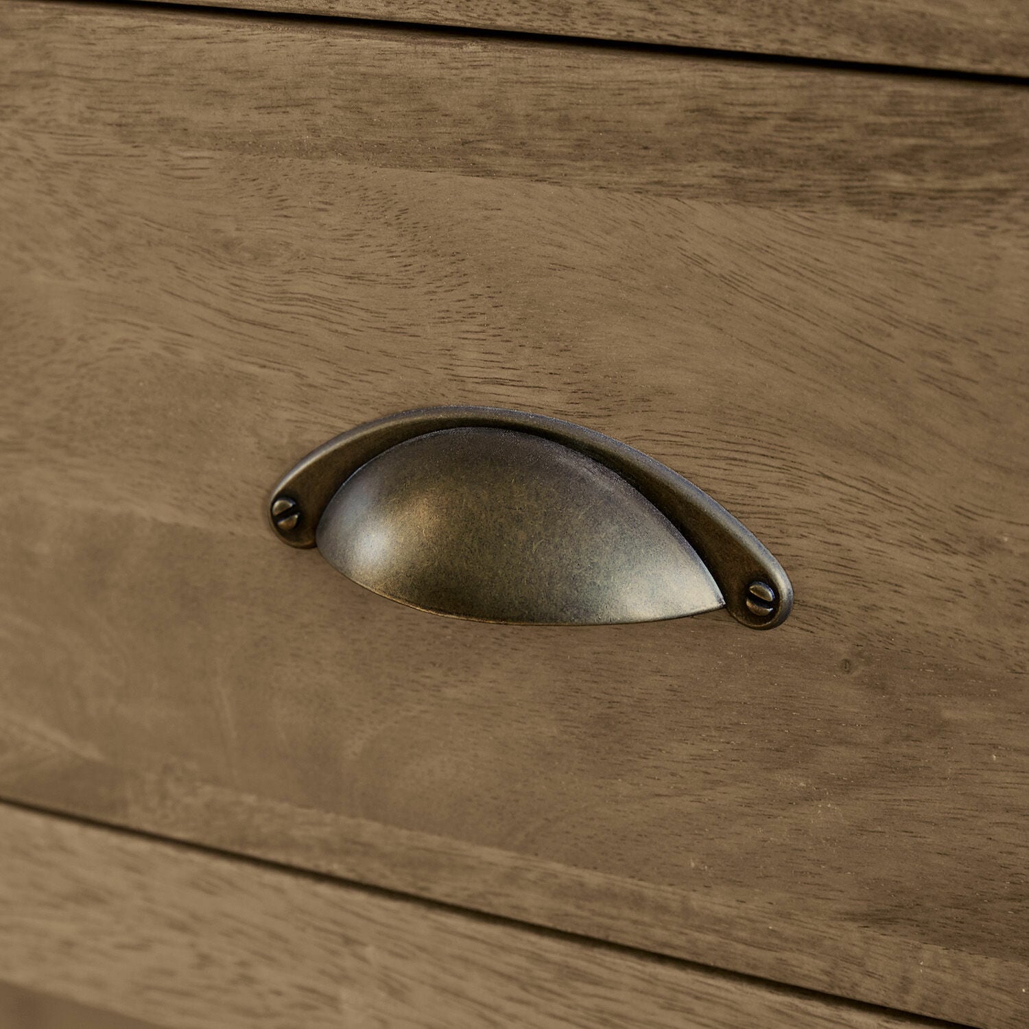 Möbelgriff aus Messing-Metall an Schublade aus Holz in Naturfarbe