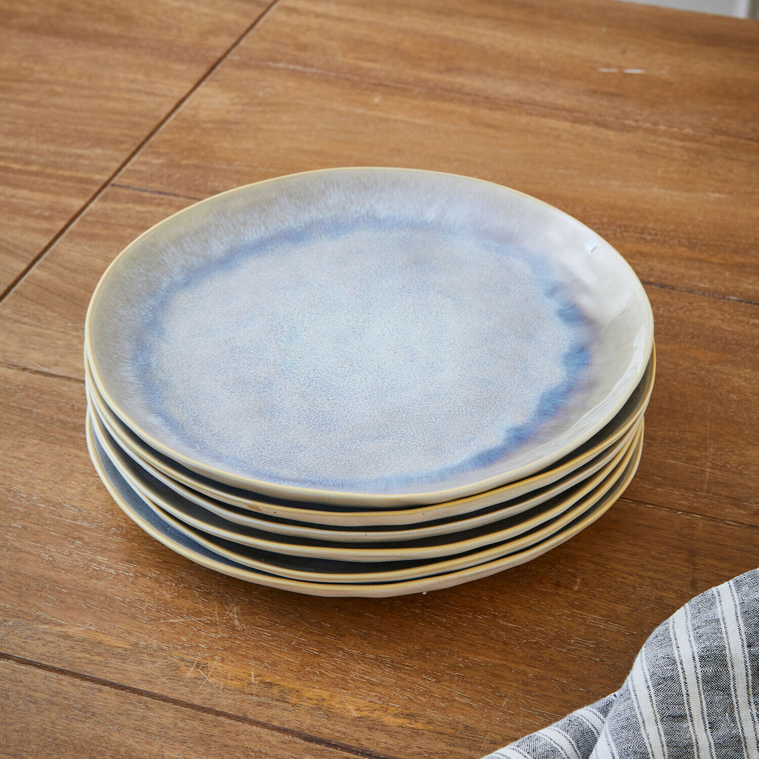 Sechser-Set Keramikteller in Blau- und Beigetönen auf Holztisch gestapelt