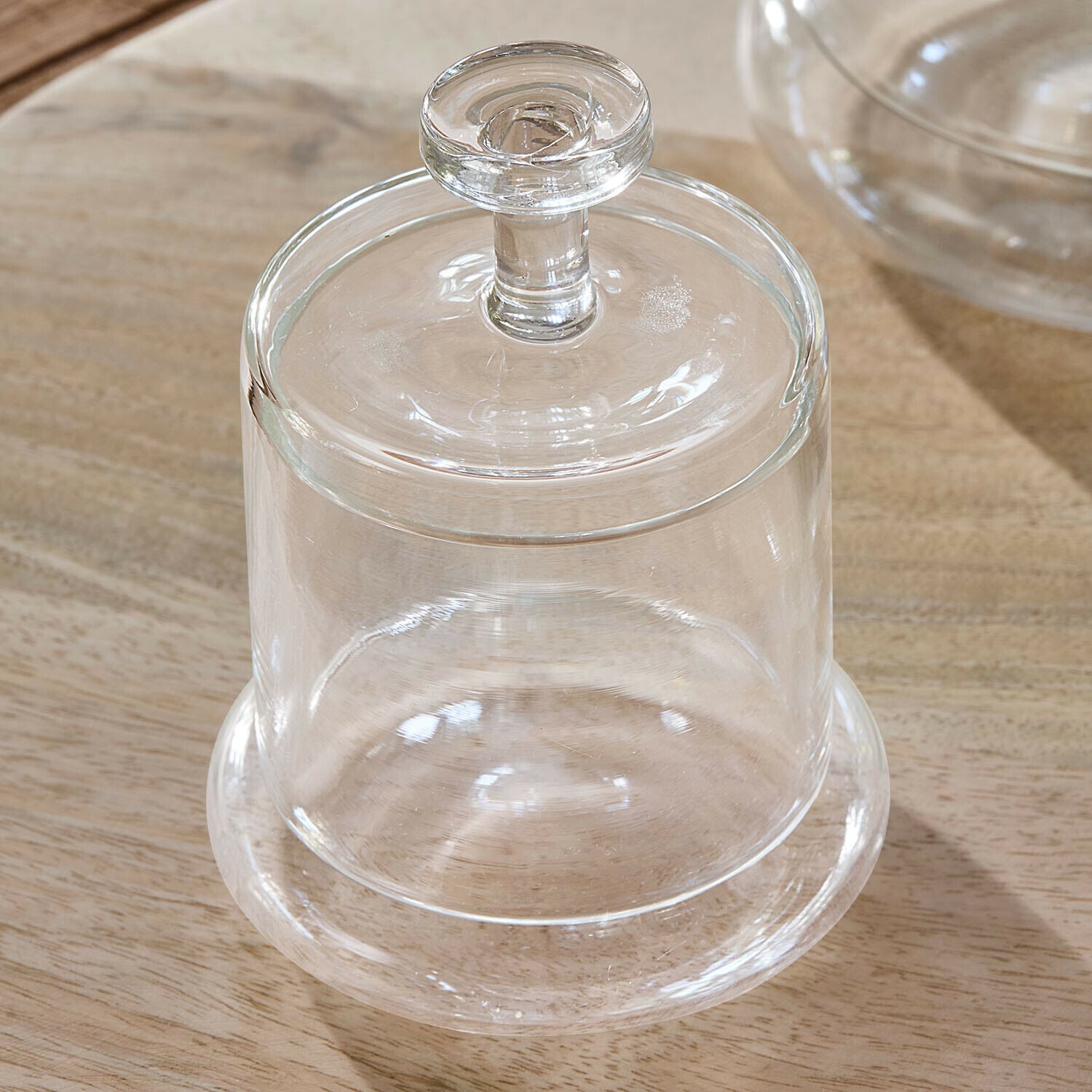 Transparente Glasglocke mit Griff auf Holztisch, praktisches Küchenzubehör