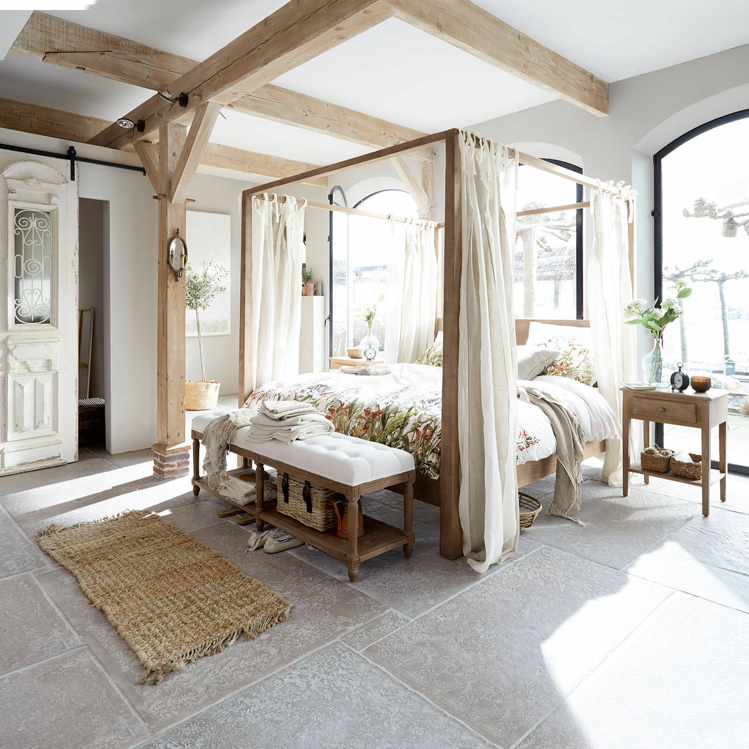 Schlafzimmer mit hellem Holz-Baldachinbett und weißen Vorhängen, natürliche Materialien und Dekor