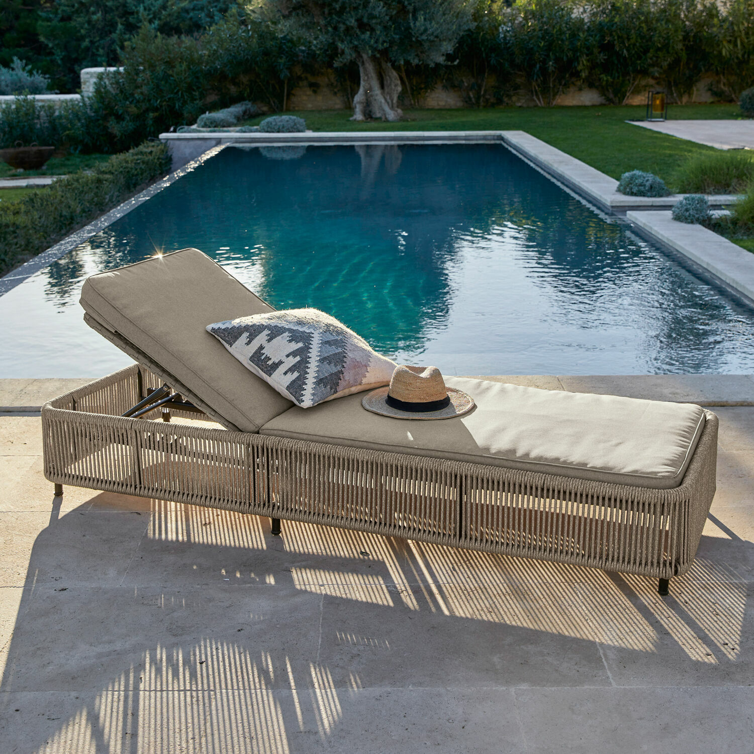 Beiger Gartenliegestuhl mit Polster und geflochtenem Gestell am Pool, Outdoor-Möbel