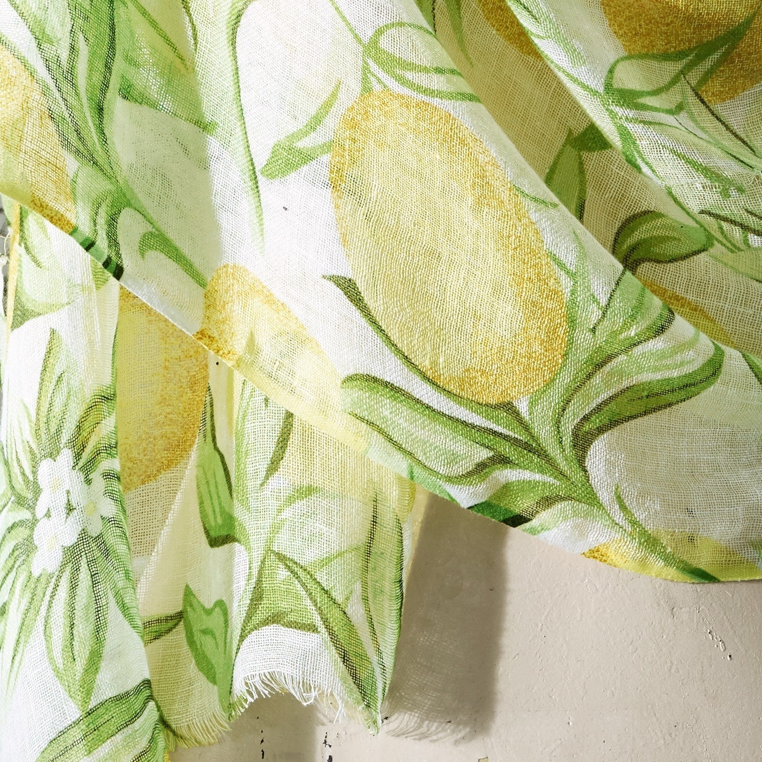 Leichter Stoff mit Zitronen- und grünen Blättermotiven auf weißem Hintergrund, Wohnaccessoire.