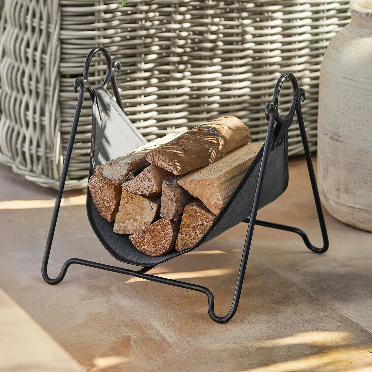 Schwarzer Metall-Holzkorb mit Stoffeinsatz, gefüllt mit Kaminholz, praktisches Kaminzubehör