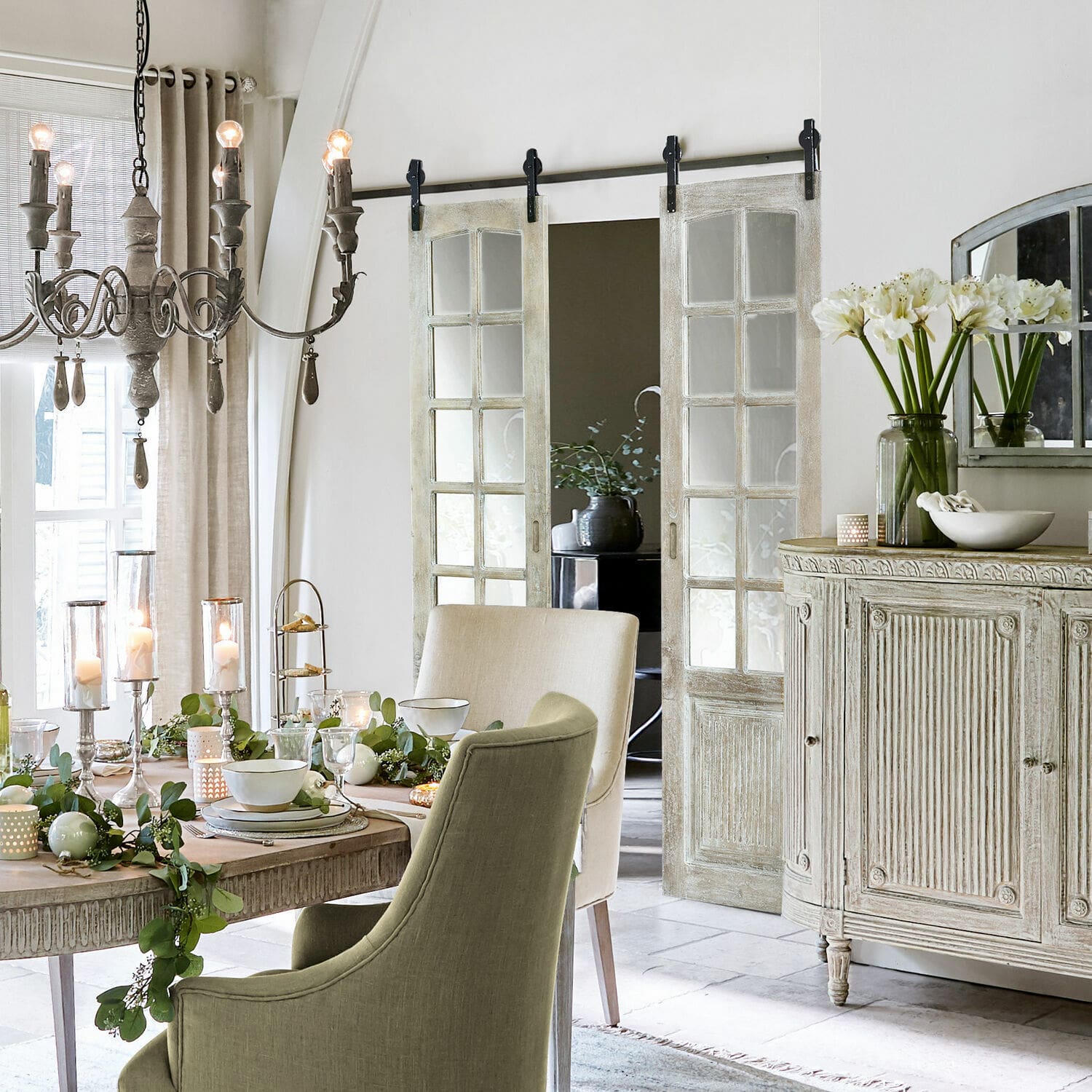 Vintage Esszimmer mit Holztisch, grünen und beigen Stühlen, Blumenarrangements und Kerzenlicht