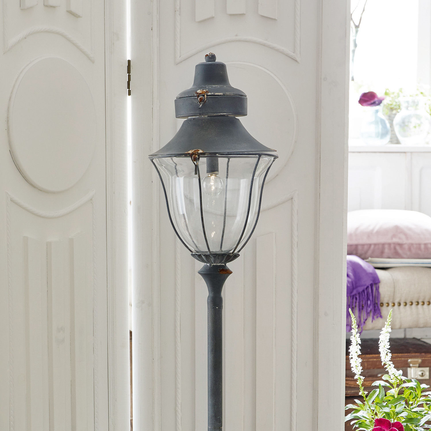 Schwarze Metall-Gartenlaterne mit klarem Glas und sichtbarer LED-Glühbirne