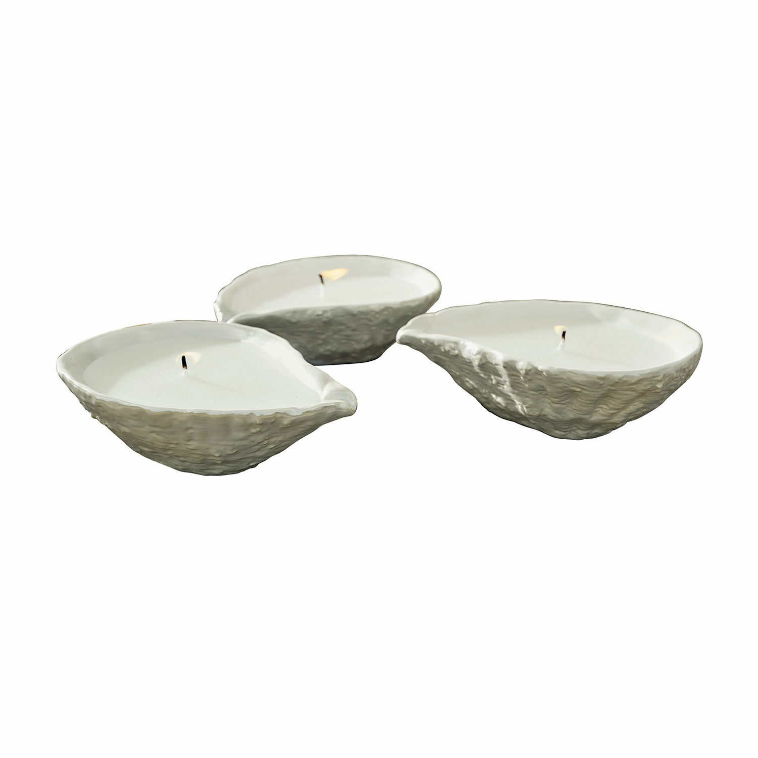 Set aus drei weißen Kerzen in muschelartig strukturierten Keramikschalen, Wohnaccessoire