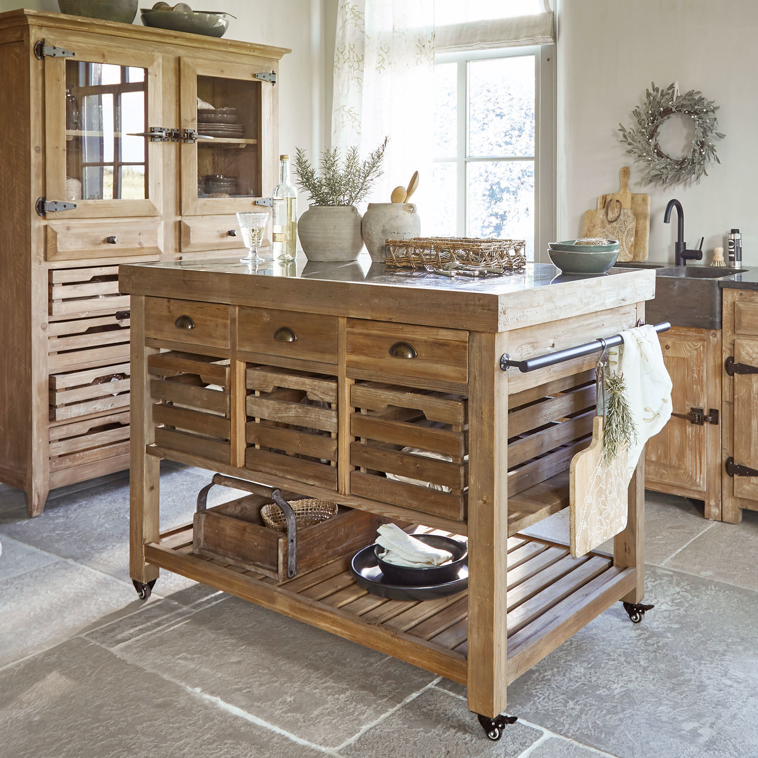 Kücheninsel aus hellem Holz mit Schubladen und Metallplatte, rustikaler Landhausstil