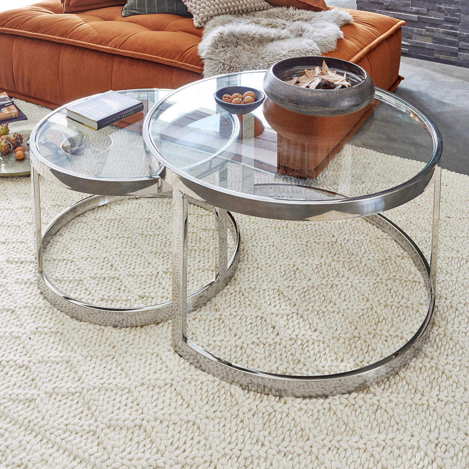 Beistelltisch 2er Set Cibran Zwei runde Couchtische aus Glas und verchromtem Stahl auf hellem Teppich