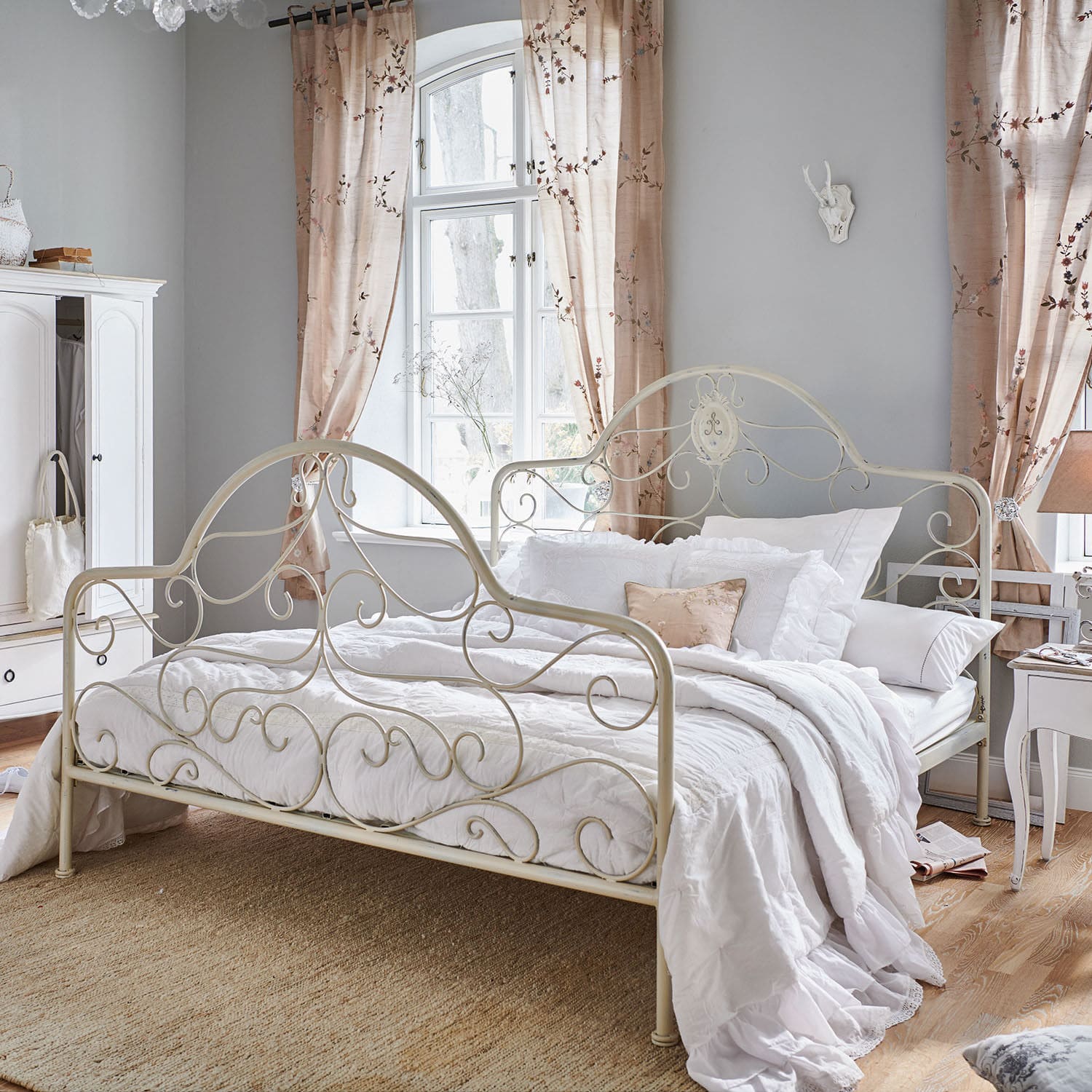 Bett Moissac Vintage Metallbett in Creme mit weißer Bettwäsche und dekorativem Kissen in gemütlichem Schlafzimmer