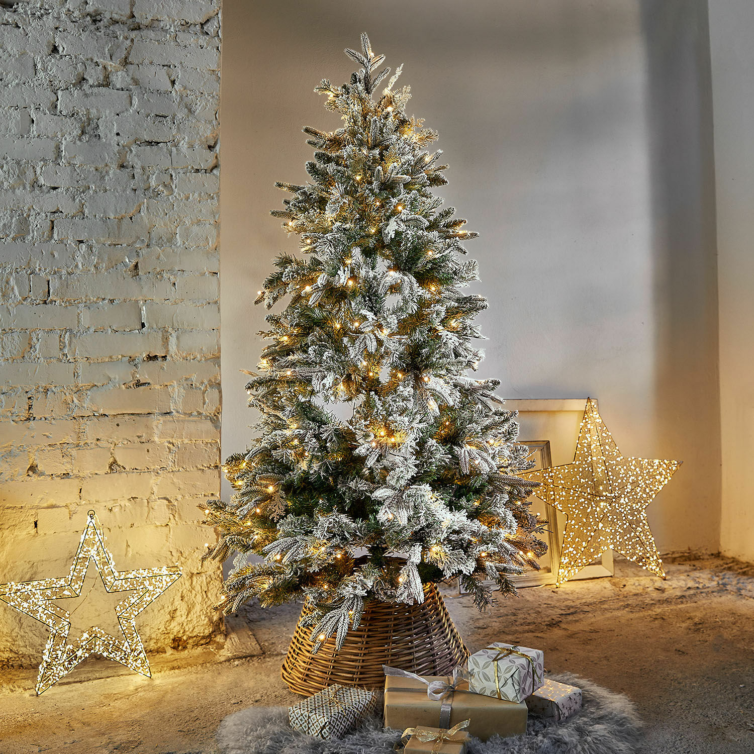 Weihnachtsbaum Cadelise Künstlicher Weihnachtsbaum mit Schneebesatz und warmen LED-Lichtern im Korbständer mit Geschenken