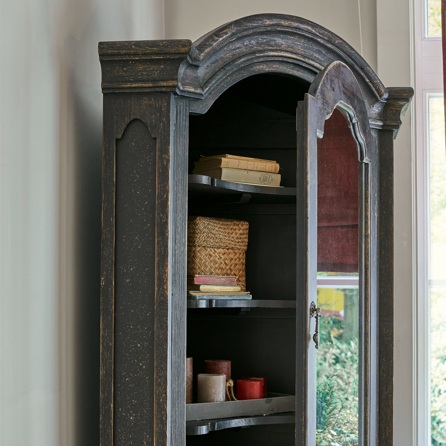 Schwarzer Holzschrank mit Spiegel und Regalen mit Büchern und Kerzen im Vintage-Stil