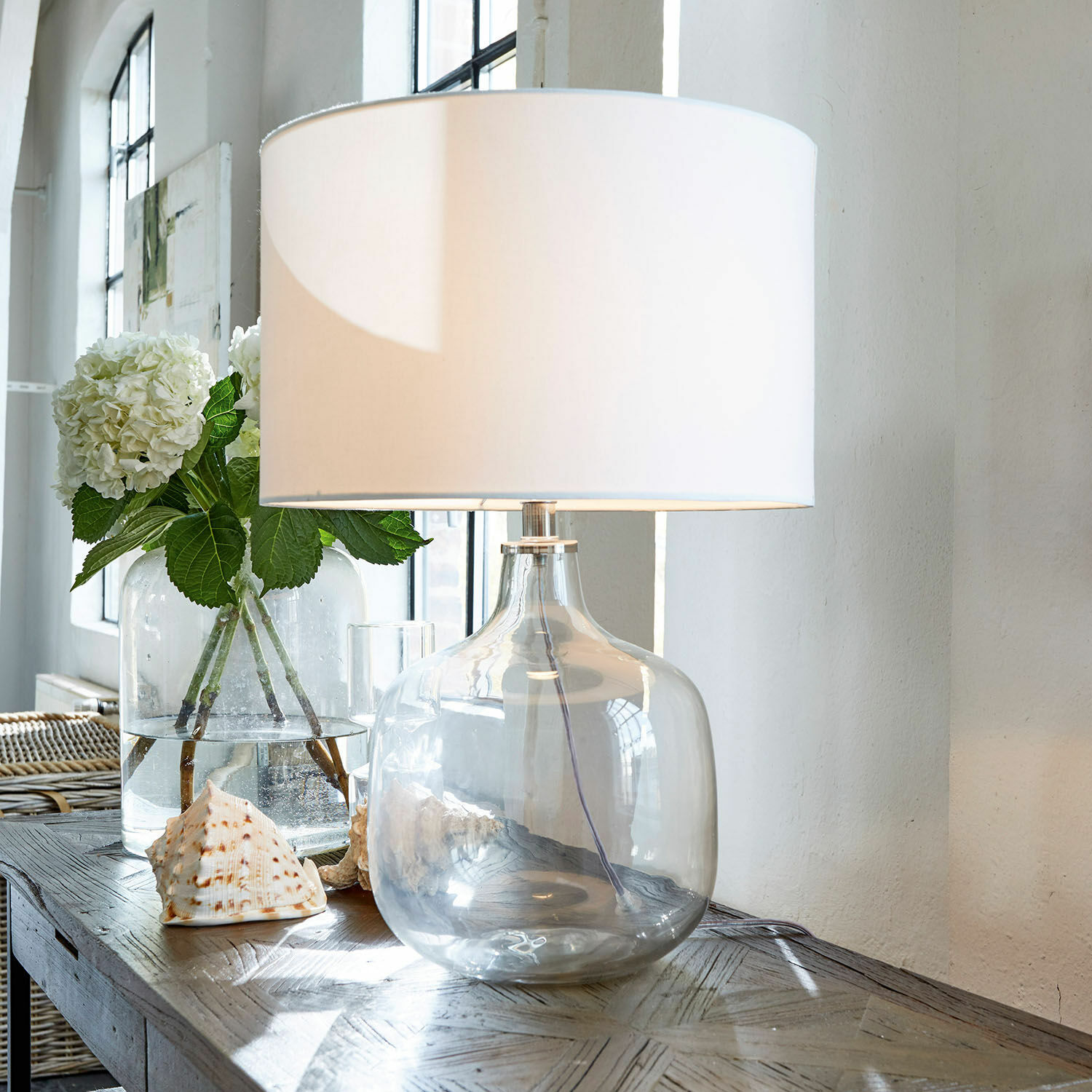 Tischlampe Malmy Tischlampe aus klarem Glas mit weißem Lampenschirm auf Holztisch mit Muscheldekor