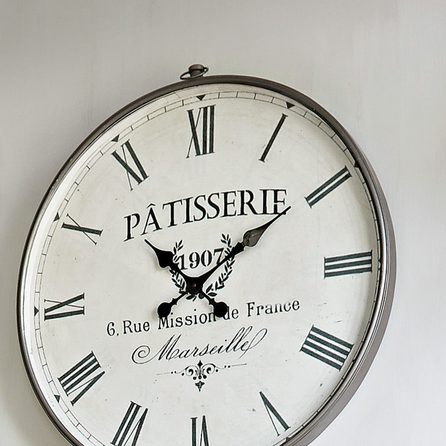 Runde Wanduhr mit Metallrahmen und römischen Ziffern im Vintage-Stil