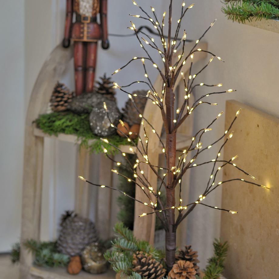 Dekorativer Lichterbaum aus braunem Material mit warmweißen LED-Lichtern und Tannenzapfen