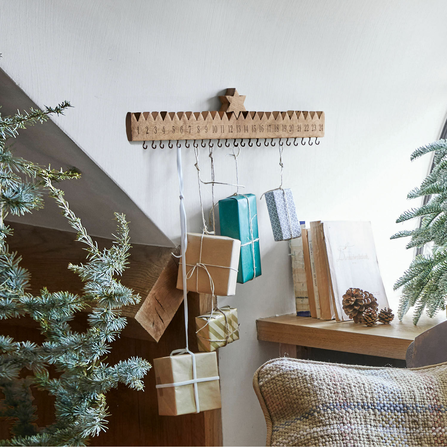 Holz-Adventskalender mit Haken und aufgehängten Geschenken in natürlicher Weihnachtsdekoration