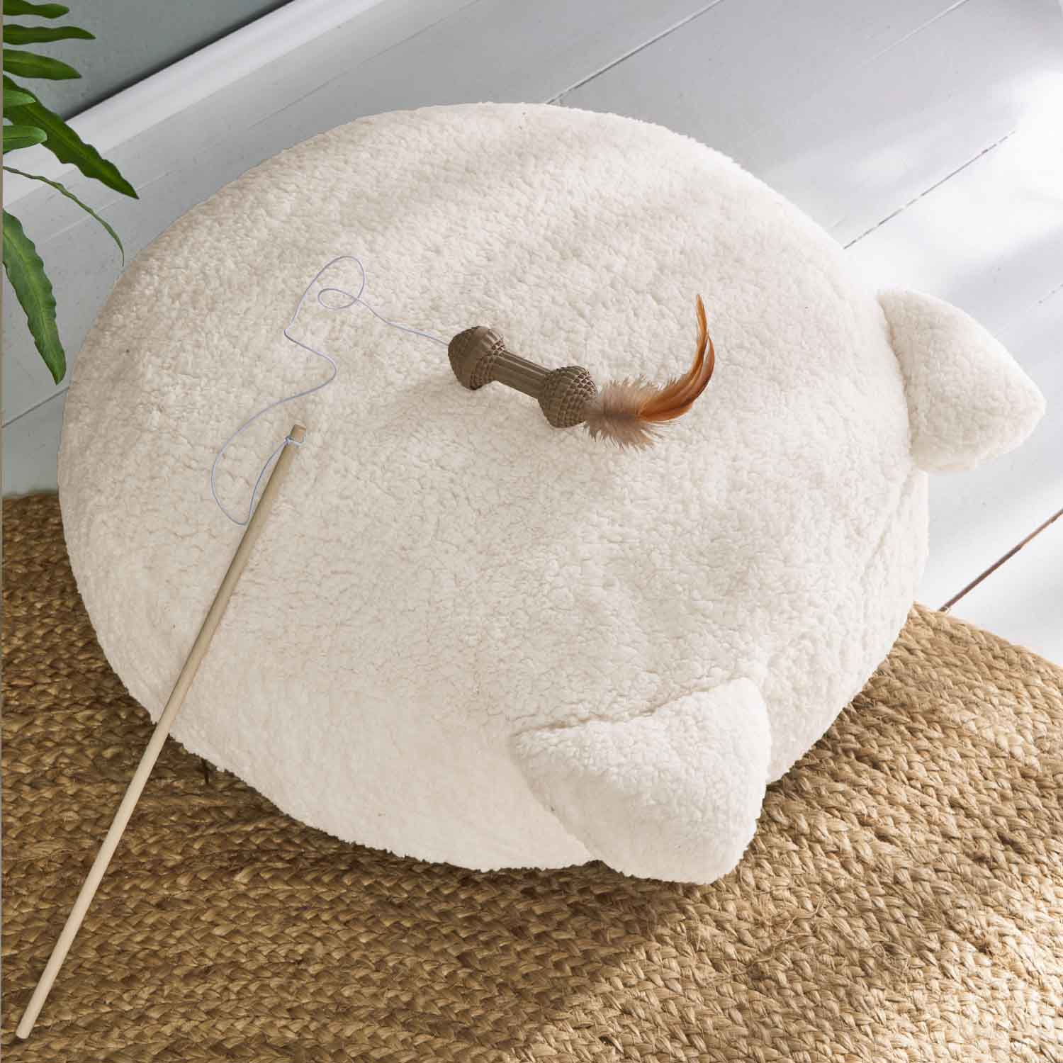 Rundes cremefarbenes Kissen aus weichem Material mit Ohren und Feder-Spielzeug für Katzen