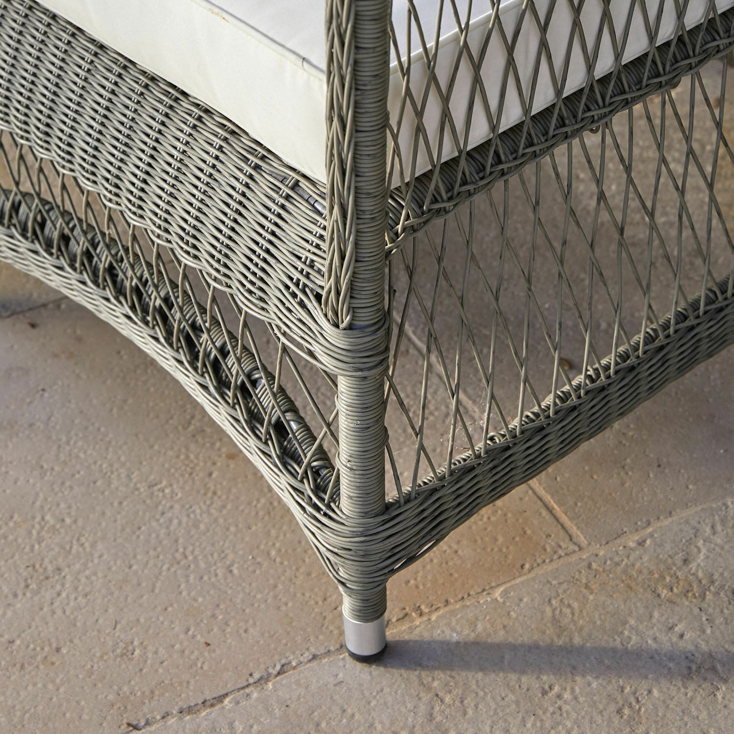 Eckteil eines grauen Rattan-Sofas mit weißem Polster, Outdoor-Gartenmöbel