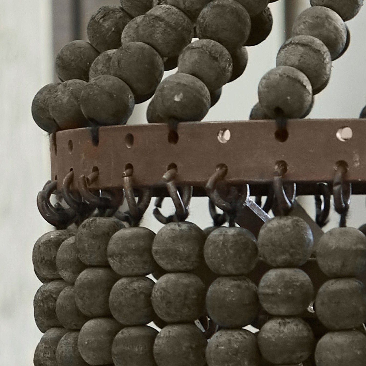 Dekoratives Element aus grauen Holzkugeln und Metallring für Wohnraumgestaltung