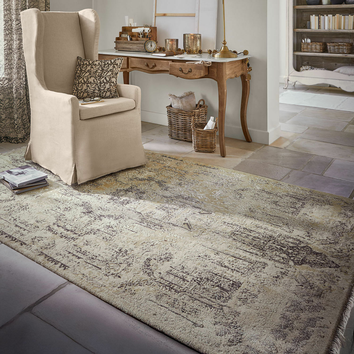 Teppich Marzahan Beiger Vintage-Teppich auf Steinboden in gemütlichem Wohnzimmer mit beigem Sessel