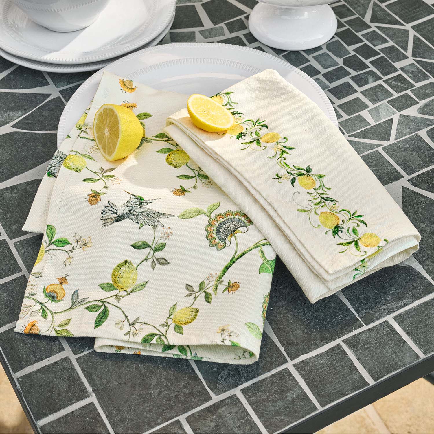 Leinen-Servietten mit Zitronen- und Vogelmotiv auf grauem Steintisch, Tischdekoration