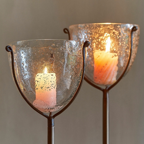 Glaswindlicht auf Metallständer mit weißer Kerze, stimmungsvolle Wohnraumdekoration