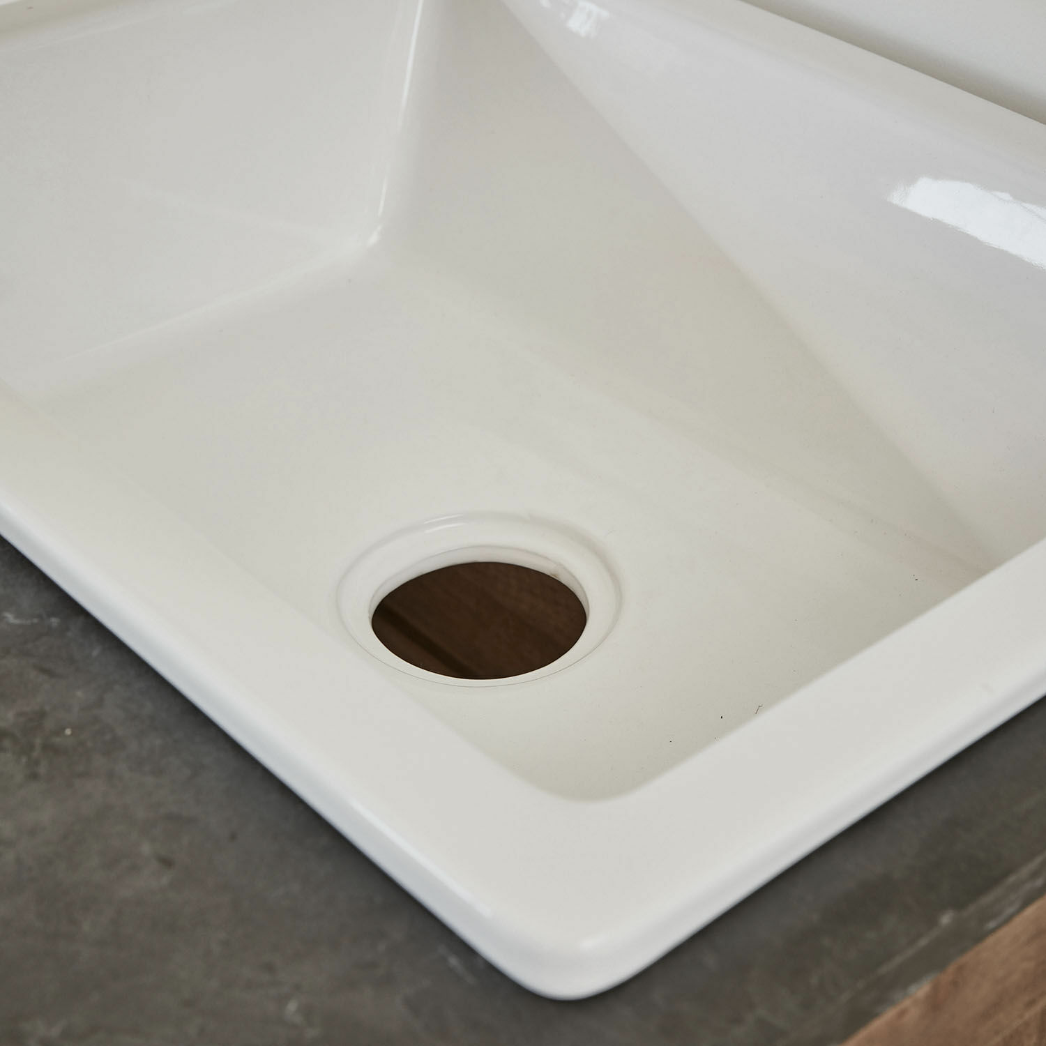 Weißes Keramikspülbecken mit Ablauföffnung auf grauer Arbeitsplatte, modernes Design