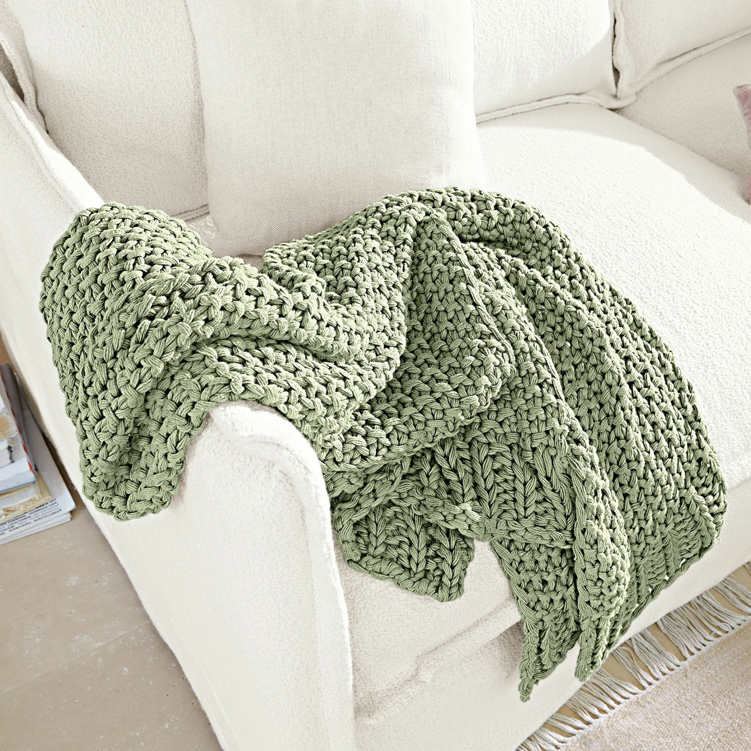 Plaid Plixoren Weiche grüne grob gestrickte Decke auf weißem Sofa, gemütliche Wohnraumdekoration
