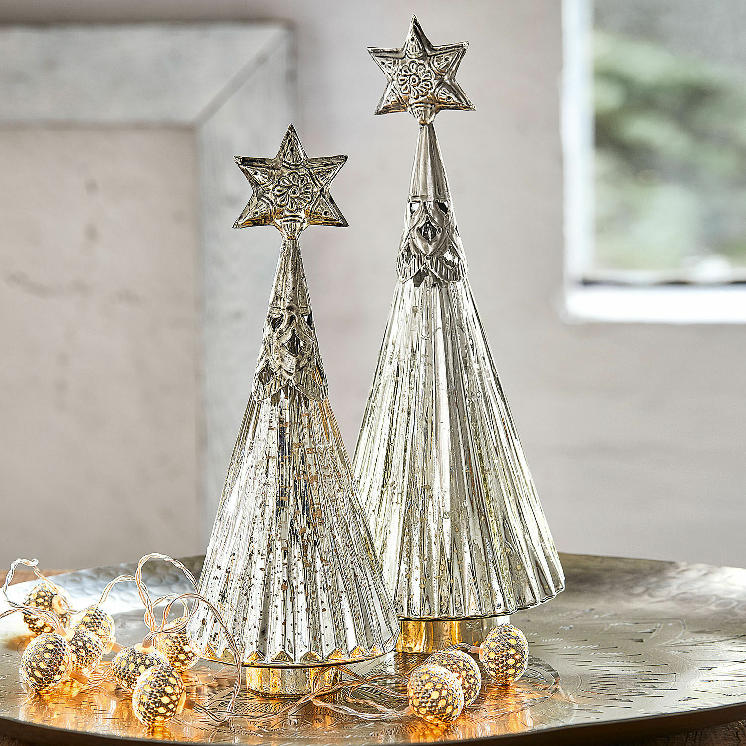 Deko-Weihnachtsbaum 2er Set Lillemor Zwei silberne Metall-Weihnachtsbäume mit Sternen oben auf festlichem Tisch mit LED-Lichterkette