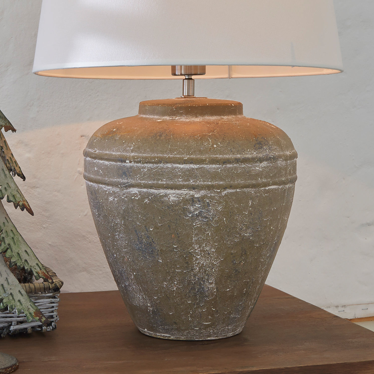 Tischlampe mit brauner, antik wirkender Keramikbasis und weißem Lampenschirm für Wohnzimmer