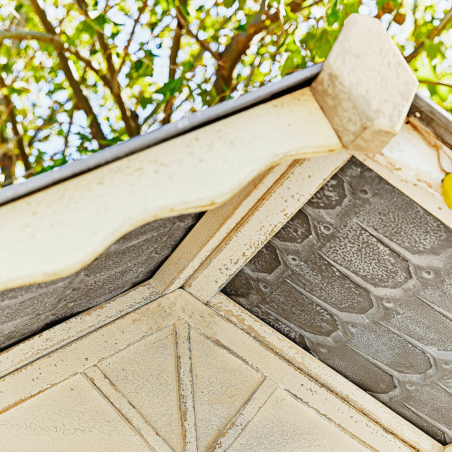 Detail eines cremefarbenen Metall-Dachs mit Struktur und Muster, dekoratives Gartenelement