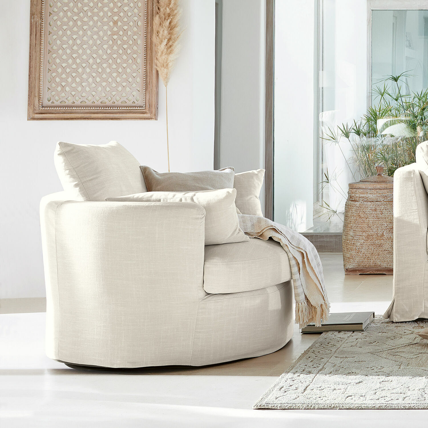 Beiger Polsterfotel aus Stoff in modernem Wohnzimmer mit Teppich und Pflanzen