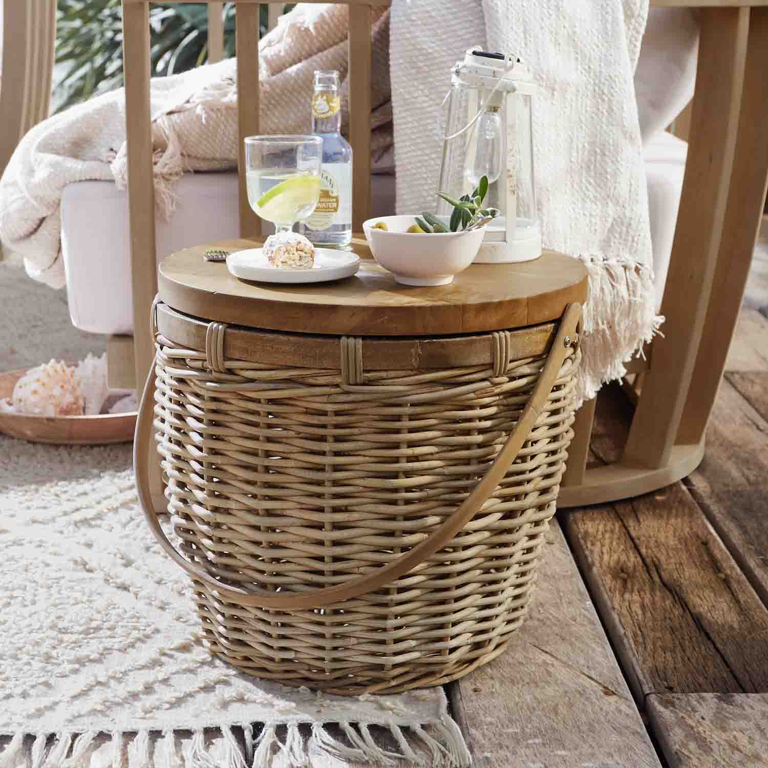 Runder Beistelltisch aus natürlichem Rattan und Holz mit Laterne und Snacks auf Holzterrasse