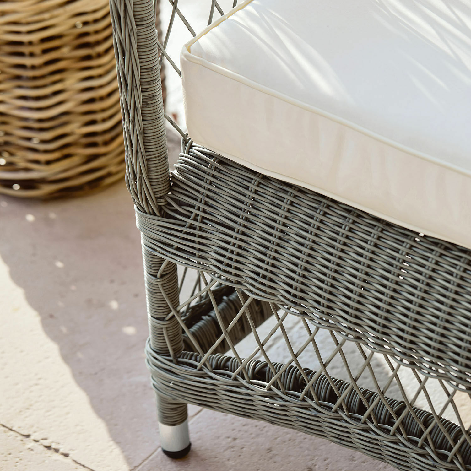 Sitzfläche aus grauem Rattan mit weißem Kissen, Gartenmöbel aus Naturmaterial
