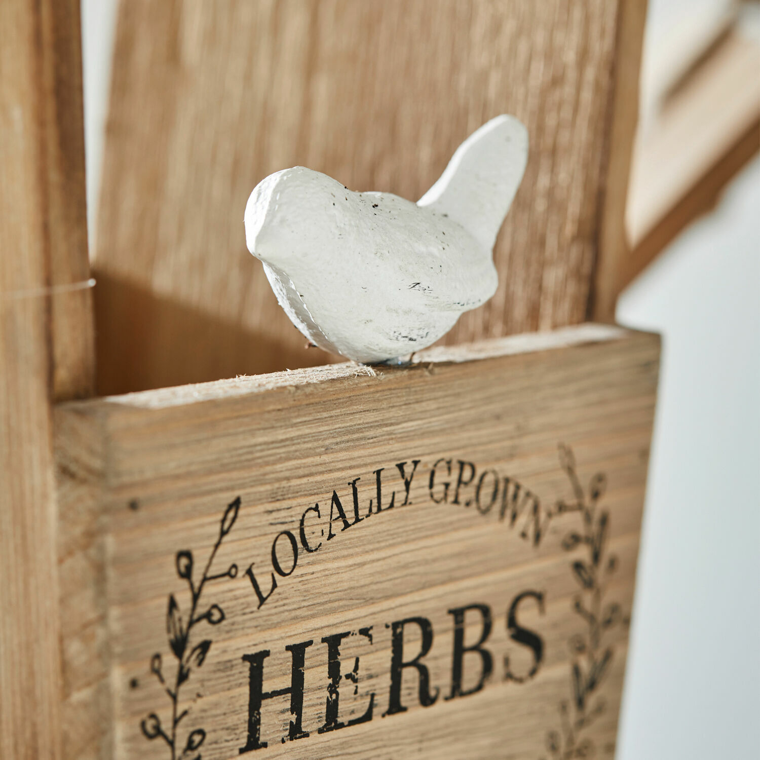 Holzschild mit Aufschrift HERBS und weißem Vogel als Dekoration, rustikaler Gartenstil